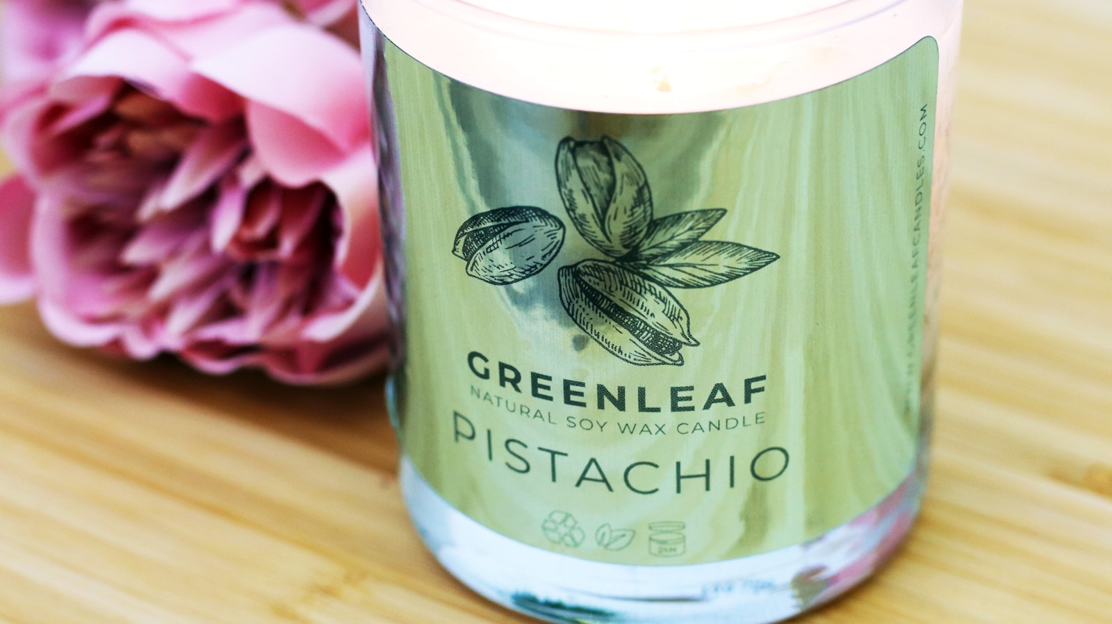 Custom printed label freshly applied to a pistachio soy candle jar